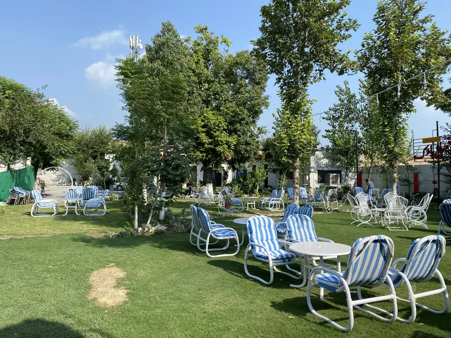 Tables set out under the trees at Safdar Hotel Family Park
